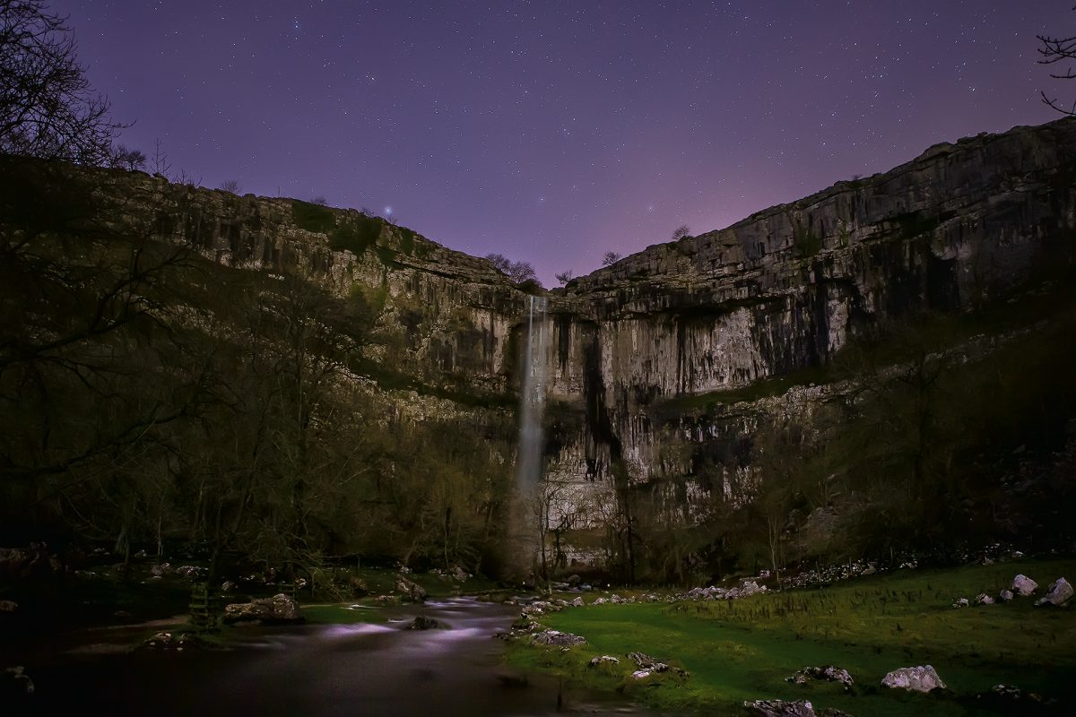 Malham Cove waterfall beneath a purple sky